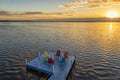 Empty chairs and table on a wooden pier at amazing colorful sunrise in the sea. Royalty Free Stock Photo