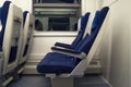 Empty chairs in the train side view. The interior of the railway wagon, carriage with blue seats Royalty Free Stock Photo