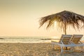 Empty chairs under thatched umbrellas on a sandy beach Royalty Free Stock Photo
