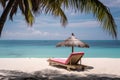 An empty chaise longue stands by the turquoise ocean. Rest near the sea