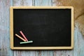 Empty chalk board with copy space on a painted wooden background. Colored chalk. Background for notes. Information board Royalty Free Stock Photo