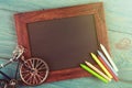 empty chalkboard with copyspace and colorful crayons on wooden table Royalty Free Stock Photo