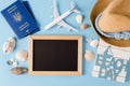 Empty chalkboard with decorative airplane, passports and seashells . Summer travel concept
