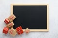 Empty chalkboard and gift boxes on light gray background