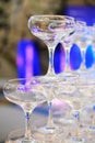 empty champagne glasses in pyramid or tower on table at wedding reception, alcohol bar, catering in restaurant. Royalty Free Stock Photo