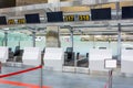 Empty check-in desks for drop off baggage with paths canceled with a red ribbon to differentiate passengers at the airport Royalty Free Stock Photo