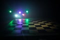 Empty chess board with smoke float up on dark background with colorful backlight Royalty Free Stock Photo