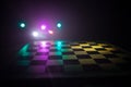 empty chess board with smoke float up on dark background with colorful backlight Royalty Free Stock Photo