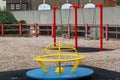 A empty children's play area or park showing a roundabout and swings Royalty Free Stock Photo