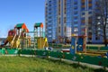 Empty children`s playground near an apartment building. Colorful slides and swings in the playground Royalty Free Stock Photo