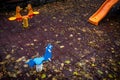 Empty childrens playground with colourful toys and leaves on the ground Royalty Free Stock Photo