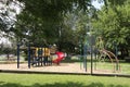 empty childrens school playground jungle gym with trees and road with cars. p