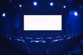 Empty cinema auditorium with empty white screen. Empty rows of theater or movie seats. Blue toned