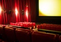 Empty cinema with blank screen and rows of red seats Royalty Free Stock Photo