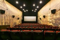 Empty cinema hall. Red seats on the background of a white movie screen