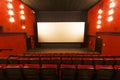 Empty cinema hall. Red seats on the background of a white movie screen