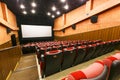 Empty cinema hall. Red seats on the background of a white movie screen Royalty Free Stock Photo