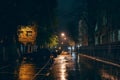 Empty city street in rainy weather at night illuminated by city lamps, no people, wet and puddles with reflection Royalty Free Stock Photo