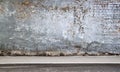 empty city street with wall with partially collapsed brickwork, pedestrian sidewalk and asphalt roadway. street wall background.