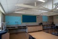 Empty classroom with blank decorations and tables and chairs stacked during summer