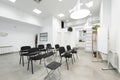 An empty classroom with a bunch of black chairs with armrests with a swing table, a whiteboard for deleble ink markers Royalty Free Stock Photo