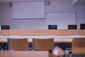 Empty classroom, with chairs, tables, with computers and projector screen Royalty Free Stock Photo