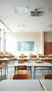 Empty classroom with rows of desks and chairs under bright overhead lighting Royalty Free Stock Photo