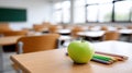 An empty classroom shows an apple and colored pencils on the desk. The space invites thoughts of learning and creativity Royalty Free Stock Photo