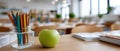 An empty classroom shows an apple and colored pencils on the desk. The space invites thoughts of learning and creativity Royalty Free Stock Photo