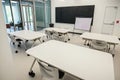 Empty classroom with white tables and chairs, a whiteboard and a blackboard Royalty Free Stock Photo