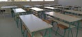 Empty classroom with wooden desks, chalk board and big windows in school. New light tables in the classroom. New school Royalty Free Stock Photo