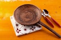 Empty clay pan with cutlery on yellow table Royalty Free Stock Photo
