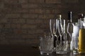 Empty clean glasses for wine, champagne, cocktails and bottles of alcoholic driks on the table agaisnt brick wall.Night at the bar Royalty Free Stock Photo