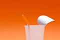 empty clean yogurt cup with spoon on an orange background Royalty Free Stock Photo