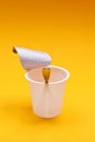 empty clean yogurt cup with spoon on an orange background Royalty Free Stock Photo