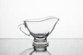 Empty clear glass gravy boat isolated on a white background