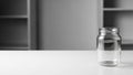 Empty clear glass jar on white surface in minimalistic setting Royalty Free Stock Photo