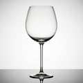 Empty Clear Glass Wine Goblet on a Reflective Surface with a Gradient Background wine glass Royalty Free Stock Photo