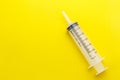 Empty clear syringe on yellow background