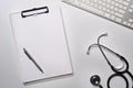Clipboard and stethoscope on white table.Empty clipboard and stethoscope on white table. Royalty Free Stock Photo