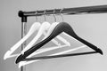 Empty clothes hangers on metal rail against grey background. Rectangular metal clothing rail with empty white and black Royalty Free Stock Photo