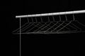 Empty coat hanger on a white bar, black background Royalty Free Stock Photo