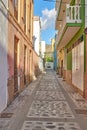 Empty cobbled street in a rural European tourist town. A quiet narrow alley way with colorful apartment buildings or Royalty Free Stock Photo