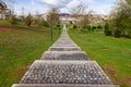 Empty cobblestone path, track, trail or pathway through the trees and green grass lawn