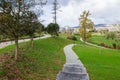 Empty cobblestone path, track, trail or pathway through the trees and green grass lawn