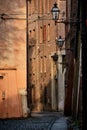 Empty street in the historic center of Ferrara in Italy with old houses painted in ochre at sunset Royalty Free Stock Photo