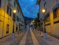 Empty cobblestone street leads through idyllic village in Italian countryside.