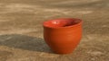 Empty coffee cup Bhar clay bowl in bright sunset light. Summer fresh cool look. Muddy mud tea cup for hot drink on rough cement