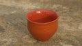 Empty coffee cup Bhar clay bowl in bright sunset light. Summer fresh cool look. Muddy mud tea cup for hot drink on rough cement