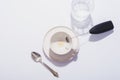 Empty coffee cup, glass of water, spoon and black milk frother on white table. Top view, flat lay Royalty Free Stock Photo